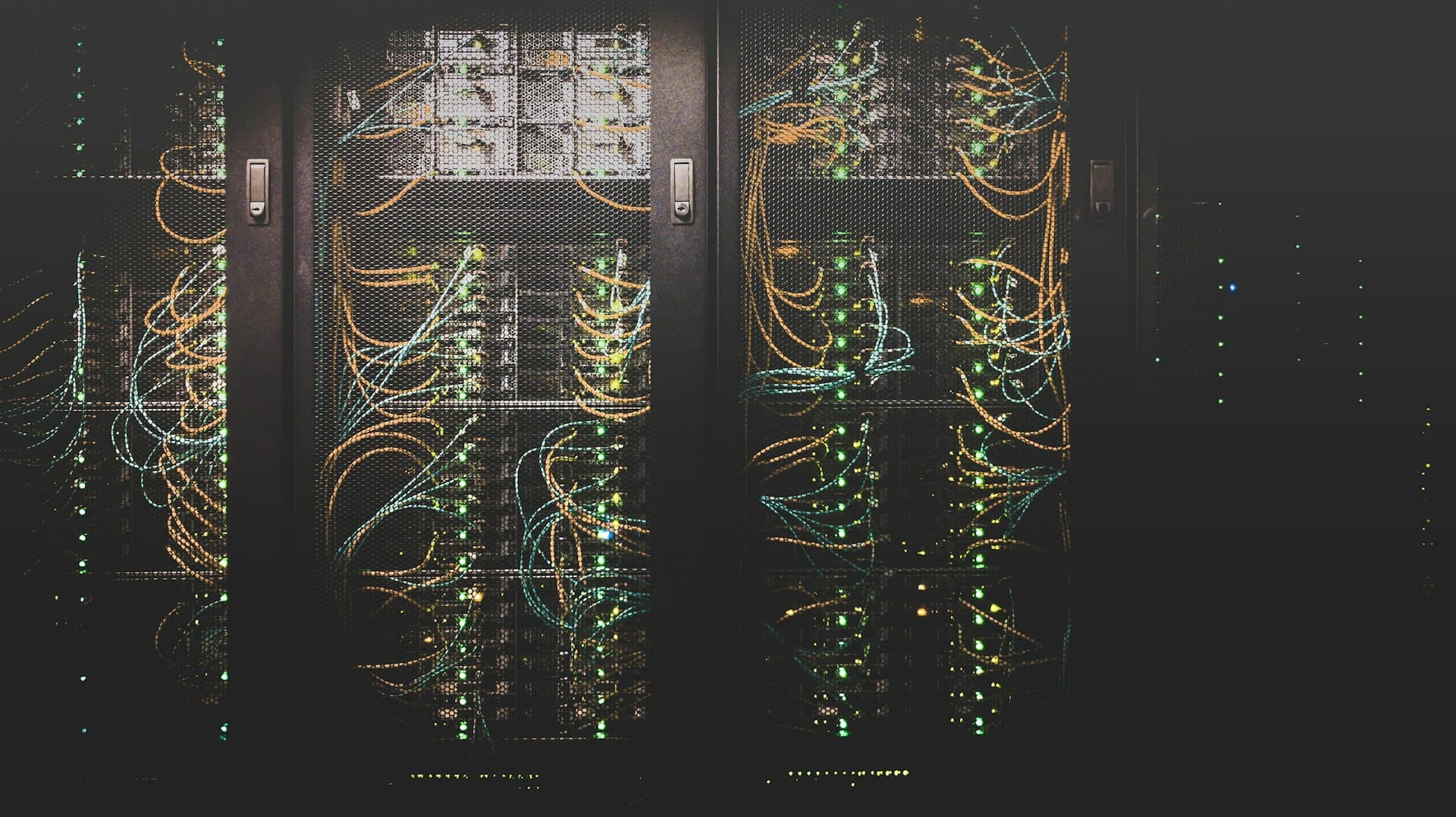Racks de servidores con cables y luces en un centro de datos oscuro